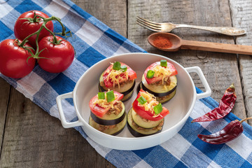 Slices of eggplant with minced meat, tomatoes and cheese ready for baking