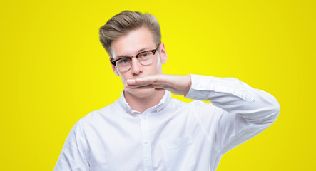 Young handsome blond man gesturing with hands showing big and large size sign, measure symbol. Smiling looking at the camera. Measuring concept.