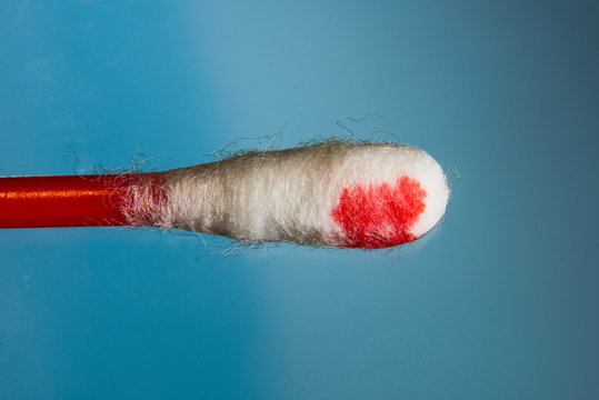 Cotton swab with blood on a blue background
