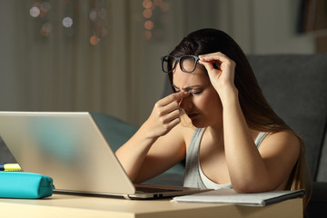 Exhausted student suffering eyestrain in the night