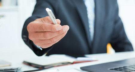 Male arm in suit offer silver pen to sign contract closeup. Strike a bargain for profit, white...
