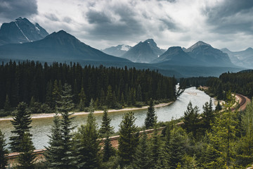 Scenic Morant's Curve with clouds and trees and mountains, Banff National Park, Alberta Canada