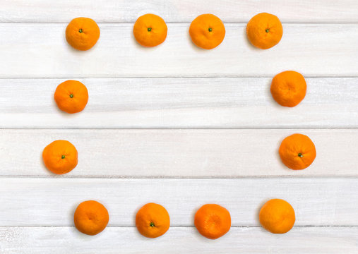 Fresh mandarin oranges on background of white painted wooden planks with space for text. Top view, flat lay