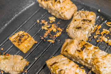 Slices of roasted salmon in a grill pan