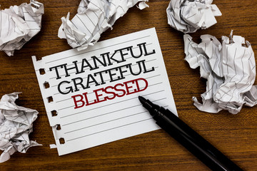 Text sign showing Thankful Grateful Blessed. Conceptual photo Appreciation gratitude good mood attitude Paper lumps laid randomly around white notepad touch black pen on woody floor.