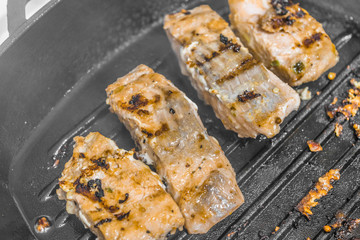 Slices of roasted salmon in a grill pan