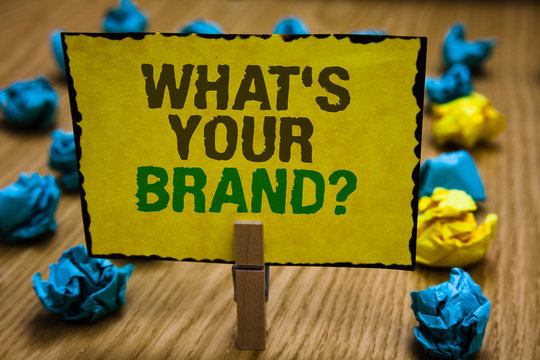 Writing note showing What s is Your Brand question. Business photo showcasing Define Individual trademark Identify Company Paperclip grip yellow page with text woody floor blue and yellow lob.