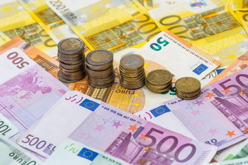 Euro coins on euro banknotes as background