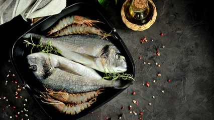 Fresh raw two dorado with rosemary, garlic and a mixture of peppers. Top view.