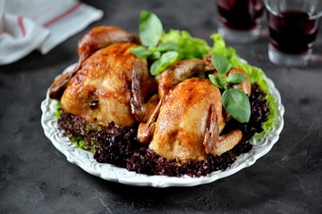 Two baked chicken with lettuce on white plate and black background.