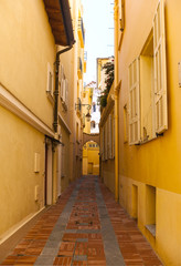 Fototapeta na wymiar Narrow cobbled street in the Monaco Old Town, dated back to the 6th century