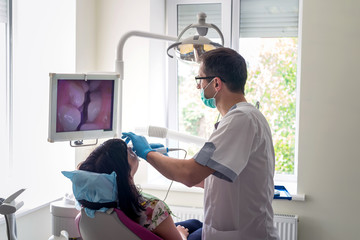 The dentist examines the patient with camera