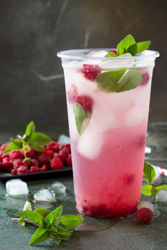 OFT DRINKS. Refreshing summer drink raspberry with basil, ice. Glasses with cold and healthy beverage on a stone or slate gray background.