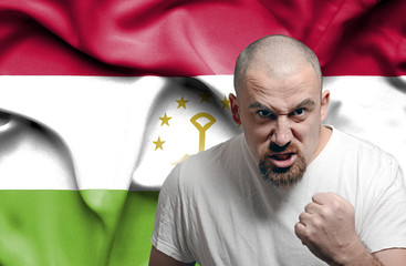 Angry man against flag of Tajikistan
