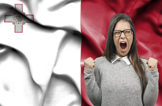 Ecstatic woman holidng fists and screaming against flag of Malta