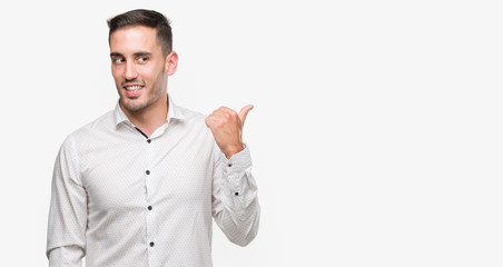 Handsome young business man pointing with hand and finger up with happy face smiling
