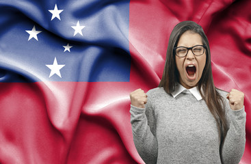 Ecstatic woman holidng fists and screaming against flag of Samoa