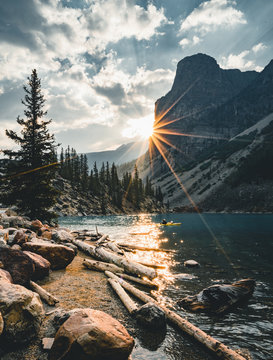 Sunrise with turquoise waters of the Moraine lake with sin lit rocky mountains in Banff National Park of Canada in Valley of the ten peaks.