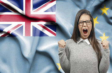Ecstatic woman holidng fists and screaming against flag of Tuvalu