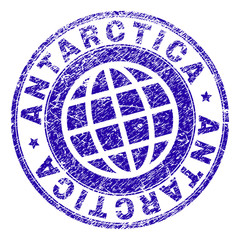 ANTARCTICA stamp print with distress texture. Blue vector rubber seal print of ANTARCTICA title with unclean texture. Seal has words placed by circle and globe symbol.