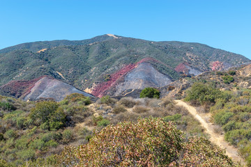 Hiking trails in California mountains on hot summer day with damage from recent forest fire ahead