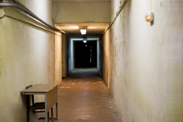 Long dark underground tunnel inside building.