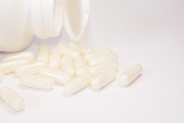 Fototapeta na wymiar White medicine or supplement capsules on white background