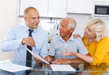 Man and woman signing agreement papers with social worker