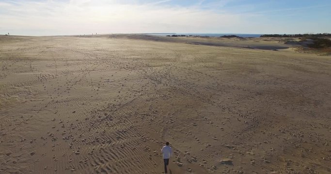 Aerial shot of person running on sand dunes Nags Head, North Carolina.