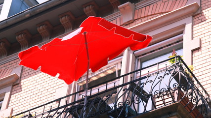 balcony with red umbrella in the city