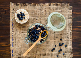 Oatmeal with berries and nuts, Healthy breakfast ingredients. Homemade granola in open glass jar...
