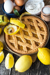 Delicious lemon pie with cooking ingredients on the wooden table 