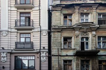 Fototapeta premium An old and new, modern building next to an ancient dilapidated building.