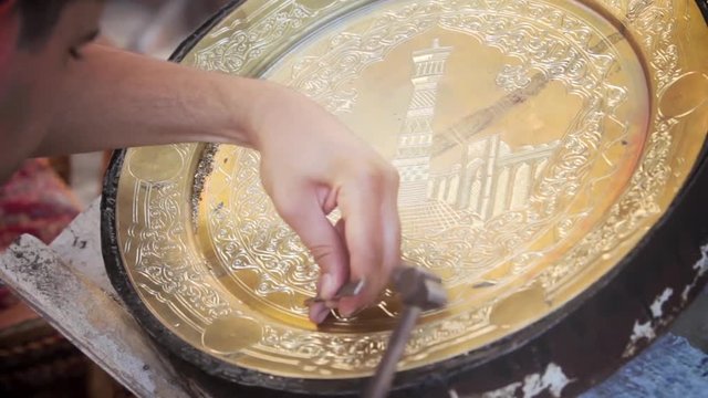Artisans carve into metal plates in the historical city of Bukhara, Uzbekistan.