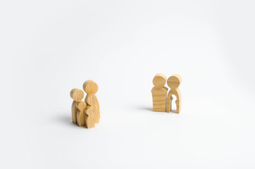 Wooden figures of people in the shape of a family and parents with the emptiness of a child inside the body on a white background. The concept of family planning, treatment of infertility.