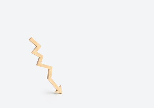 Wooden arrow graph shows down on a white background. The concept of falling and degradation, a decrease in efficiency and quality. Minimalism. Failure in business and personal life.