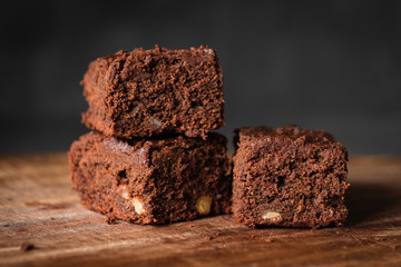 Chocolate brownies with walnuts on wood. Closeup view, selective focus