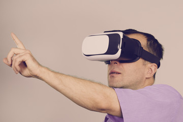 Man wearing virtual reality goggles on grey