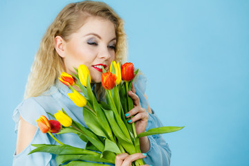 Obraz na płótnie Canvas Pretty woman with red yellow tulips bunch