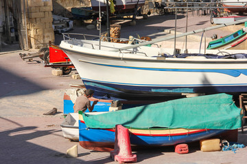 Fototapeta na wymiar Man paint traditional maltese boat in sunny day