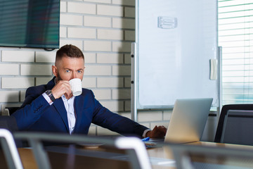 Businessman working at computer in office.