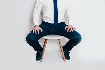 Upset and stressed man dressed in shirt and tie sitting on a chair. Concept of nervousness before...