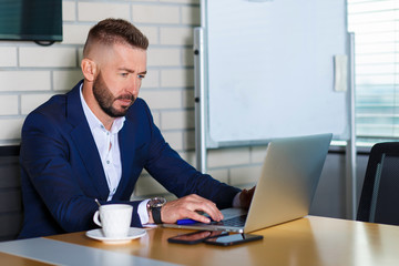 Businessman working at computer in office.