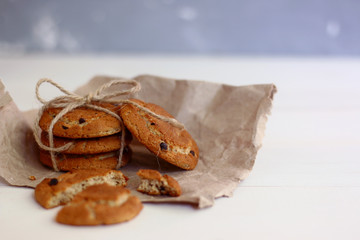 oat cookies with chocolate and bow on craft paper and light background