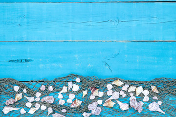 Blank teal blue sign with fish netting and seashells