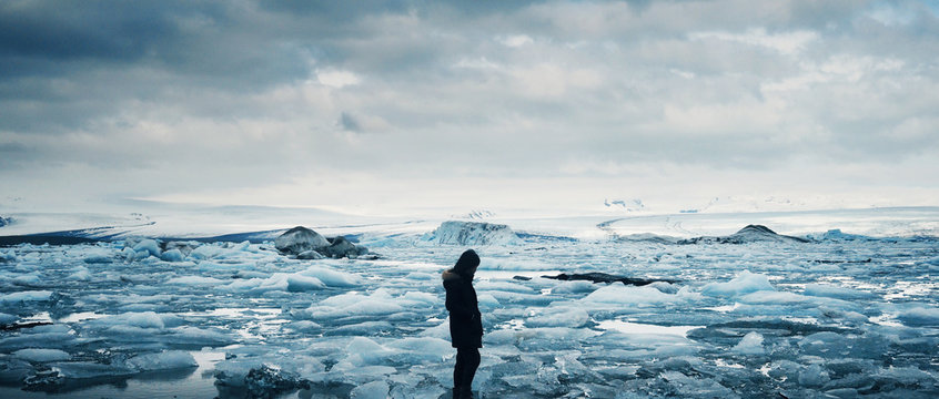 Woman looking at icebergs at diamond beach, J&ouml;kuls&aacute;rl&oacute;n in South Iceland.