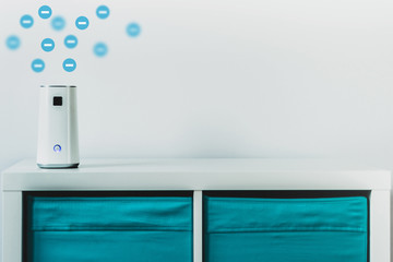 Ionizer stands on a white shelf on a white background. Air purifier during operation, emission of negative ions into the air, care for the comfort of residents, employees in the office. - obrazy, fototapety, plakaty