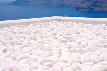 Fototapeta na wymiar Pebble stone with ocean view.. Santorini-Greece