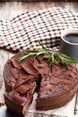 Baked  belgian chocolate cheesecake with chocolate ganache on wooden table
