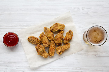 Chicken wings with sauce, cold beer on a white wooden background, top view. Flat lay, overhead.